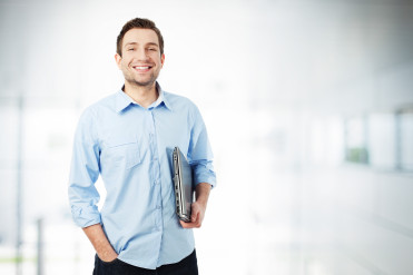 Happy businessman with laptop smiling